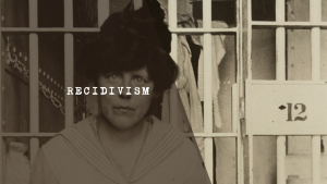 Black and white photograph of an incarcerated woman looking through prison bars